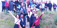 35 internationale Teilnehmende der IKEM Academy stehen nach einem Gespräch mit dem Betreiber vor einem Windpark in Berlin