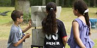 Die Kinder-Jury schaut sich ein Kunstwerk aus der Ausstellung PRÉSENT an