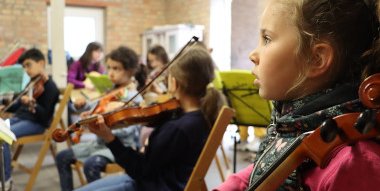 musizierende Kinder sitzend in einem Raum