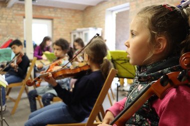 musizierende Kinder sitzend in einem Raum