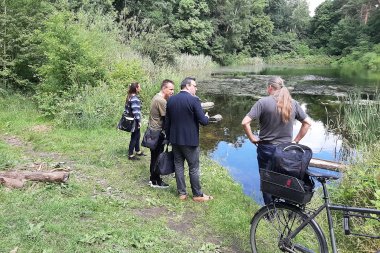 4 Personen stehend am See zur Abstimmung einer ökologischen Aufwertung am Vierling mit dem zuständigen Bezirksamt